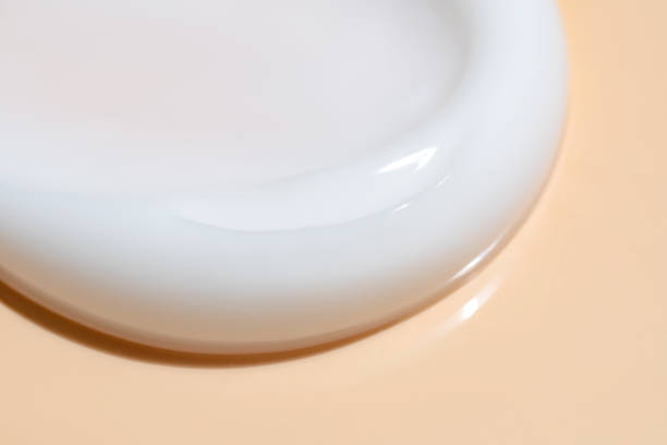 Close-up image showing a smooth, creamy texture of face makeup product on a light background.